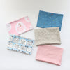 A collection of soft cotton baby pillow covers in various colors and patterns including pink, blue, and beige.