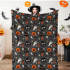 A dark gray flannel blanket featuring an all-over Halloween pattern with spiders, witches, and jack-o'-lanterns.