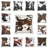 A collection of faux fur cowhide print cushion covers in various brown and white patterns.