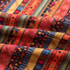 Close-up of colorful bohemian printed linen fabric featuring stripes and geometric patterns in shades of red, orange, blue, a