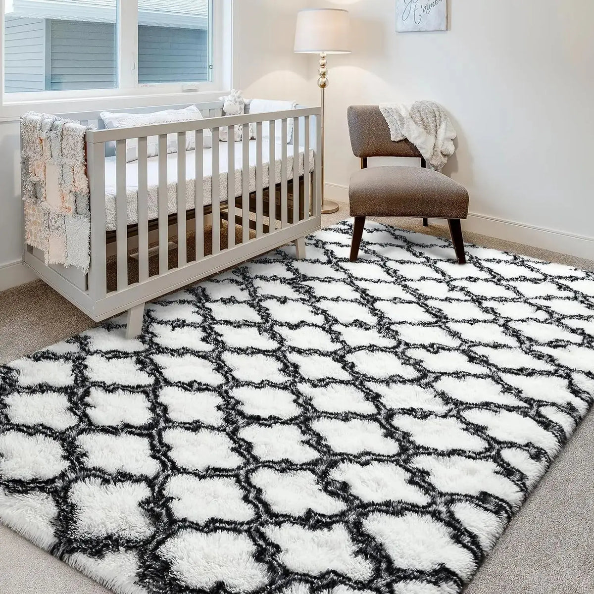 A geometric black and white faux fur area rug in a living room or bedroom setting.
