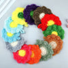 A wreath of colorful flower-shaped kitchen dish scrubbers or sponges in various vibrant colors.