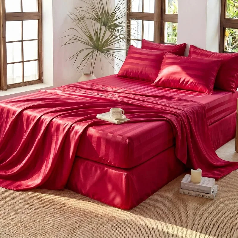 A vibrant red satin bedding set featuring a headboard and pillows on a bed with large windows.