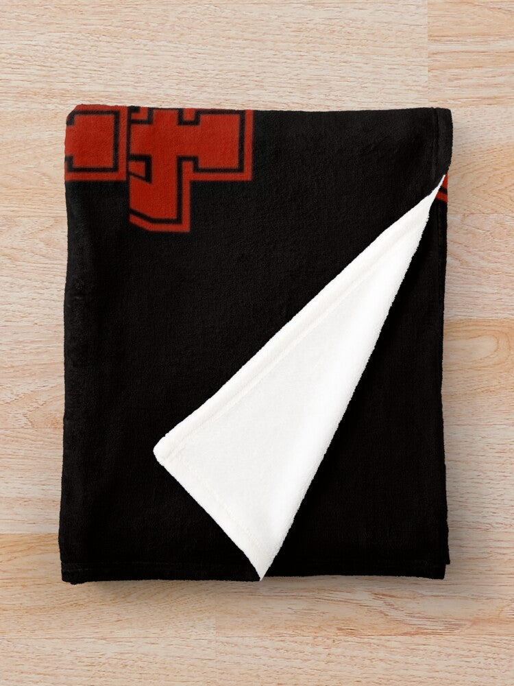 A black knitted throw blanket featuring a red cross design on the upper left corner.