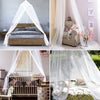 White sheer dome mosquito net draped over a wooden bed frame and a crib, used for home protection.