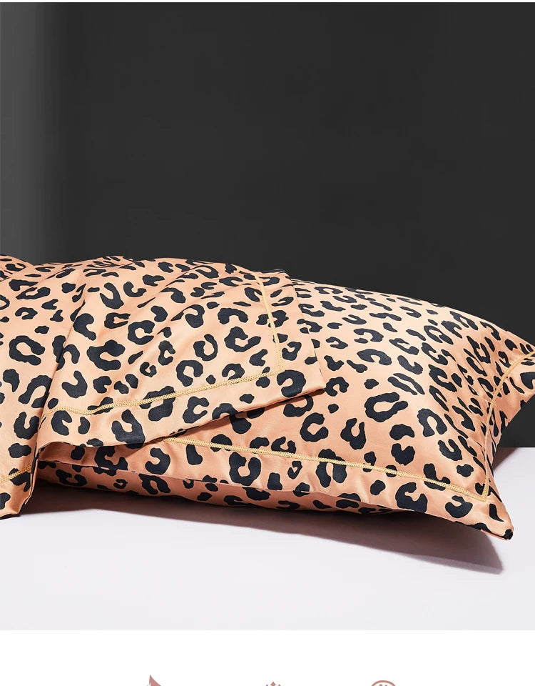 A close-up of leopard print silk satin pillowcases in a tan and black pattern resting on a white surface.