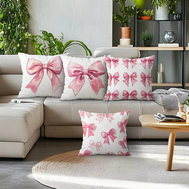 A collection of pink bow pattern decorative pillows displayed on a sofa and a wooden table.