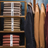 A display of stacked bed sheets in various colors and sizes, organized on wooden shelves.