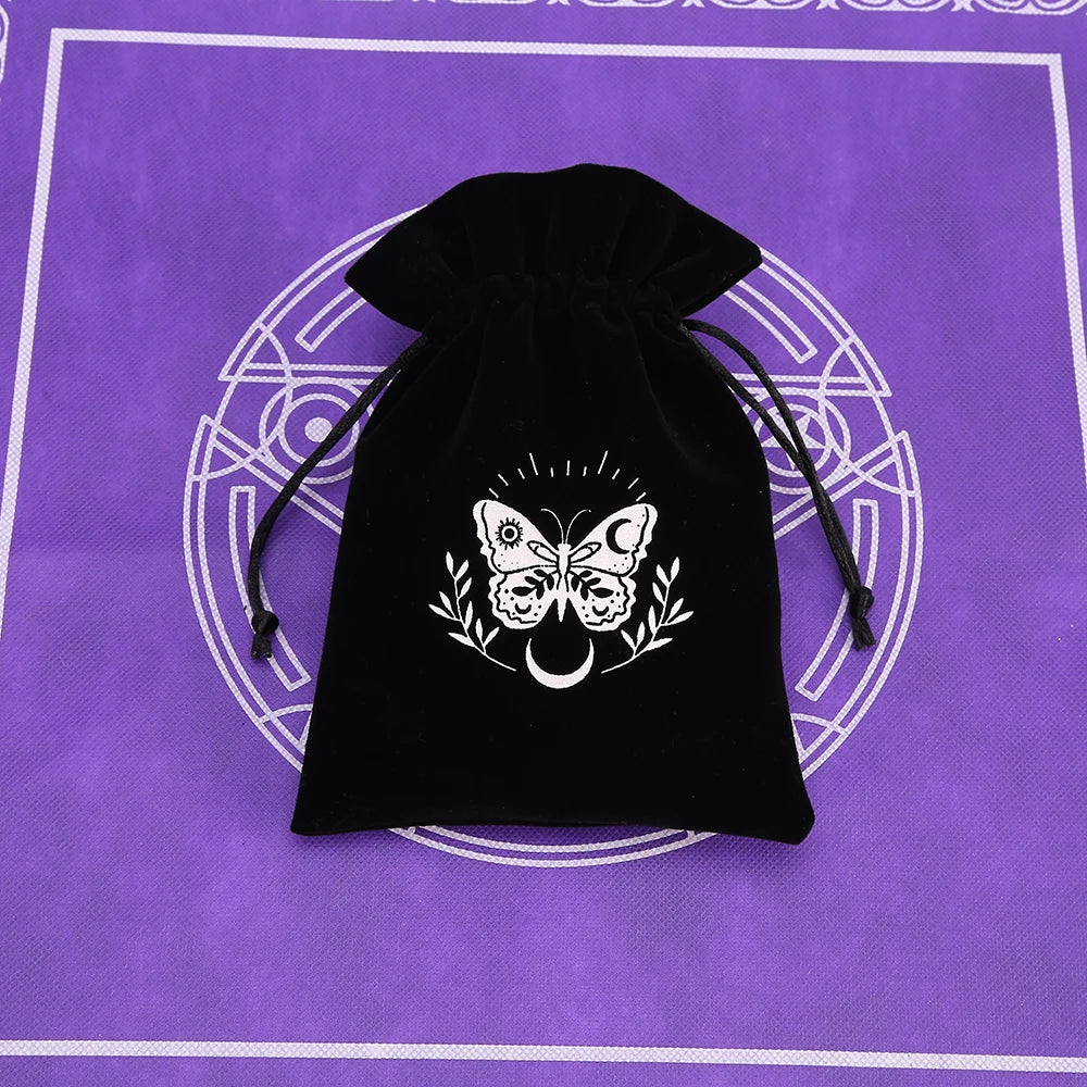 A black velvet tarot cards storage pouch with a white butterfly and crescent moon design, set against a purple background.