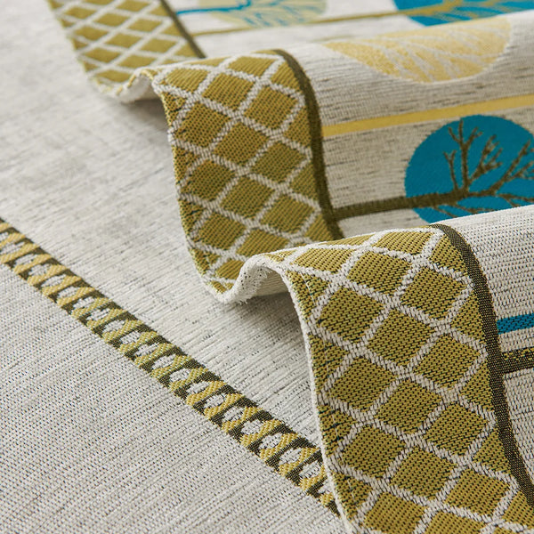 A close-up of a beige fabric with yellow and blue geometric patterns, showing a decorative trim detail.