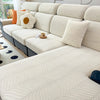 A light cream jacquard stretch sofa cover featuring a subtle wavy pattern on a modern sectional sofa.