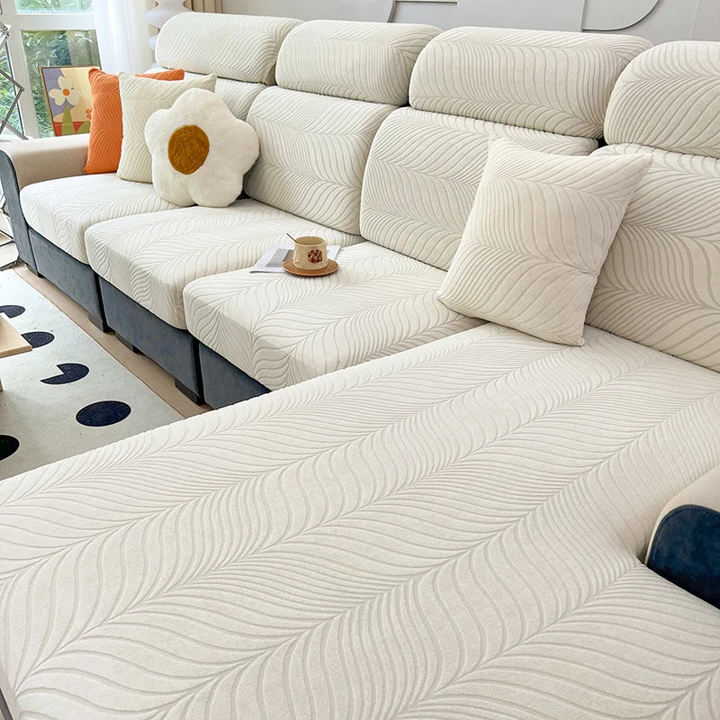 A light cream jacquard stretch sofa cover featuring a subtle wavy pattern on a modern sectional sofa.