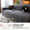 A dark gray jacquard plush elastic sofa cover with a black cushion displayed on a sofa.