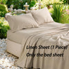 A beige linen bed sheet is draped over a bed, surrounded by greenery and decorative stones.