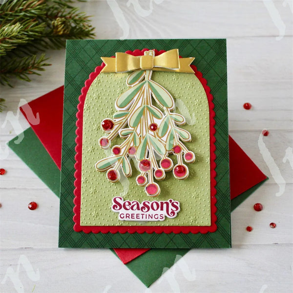 A green felt card with a gold bow and a green Christmas tree design featuring red berries.