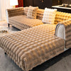 A plush velvet sofa cover with a textured, golden brown fabric and non-slip backing is displayed indoors.