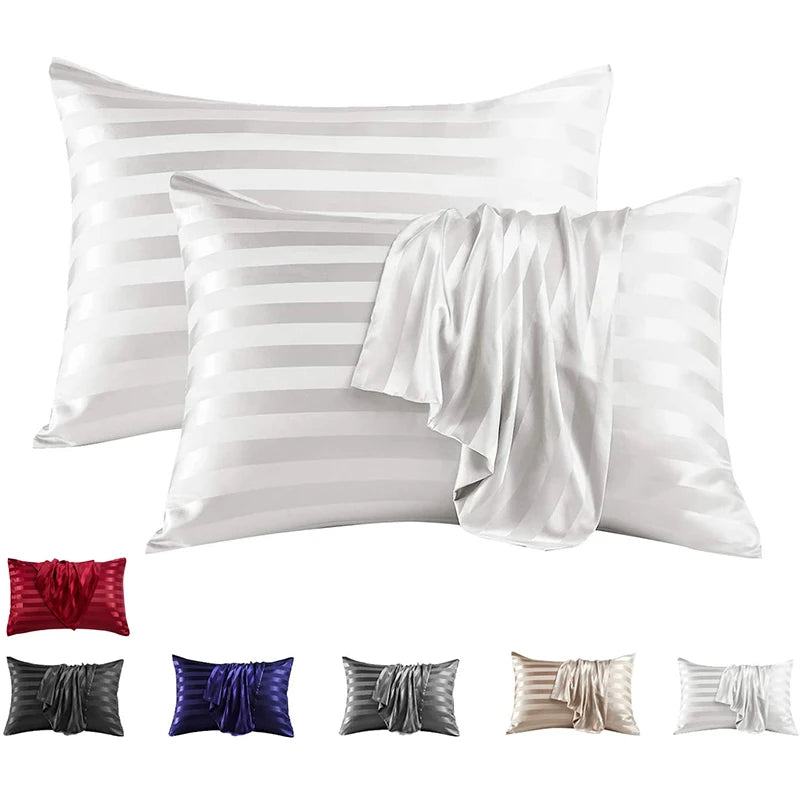A set of elegant white and silver striped pillow covers, including standard pillows and a draped fabric.