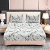 A fitted sheet set featuring a white and gray marble print on a bed with matching pillows.