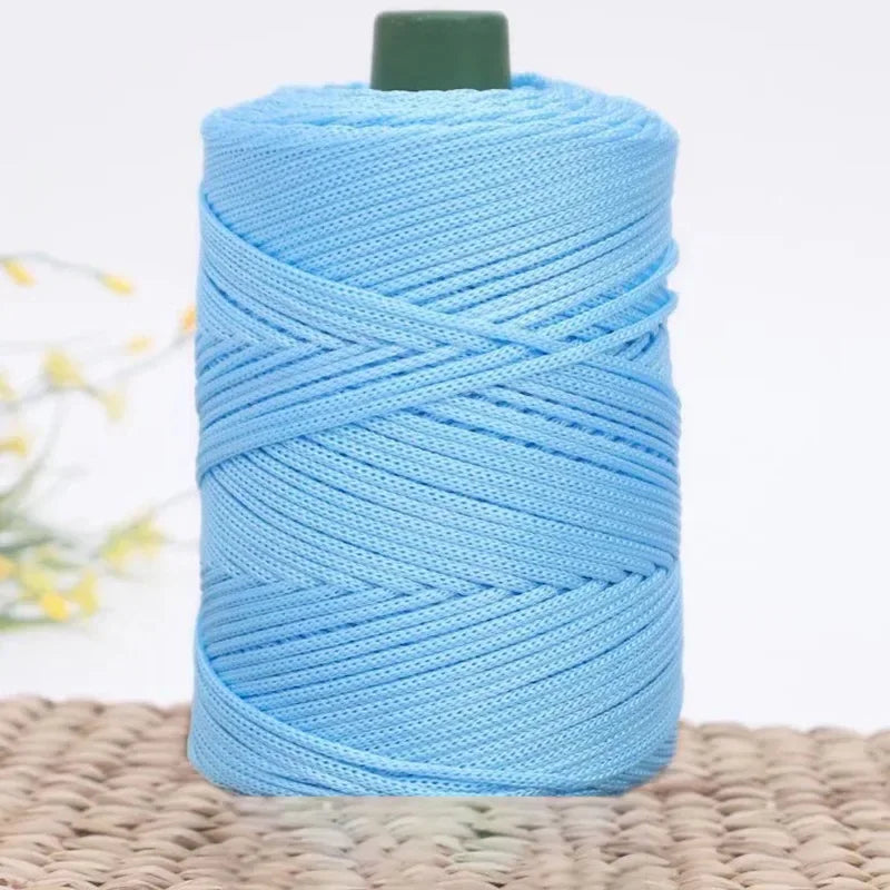 A spool of light blue 3mm ice rope crochet yarn for crafting placed on a woven mat.