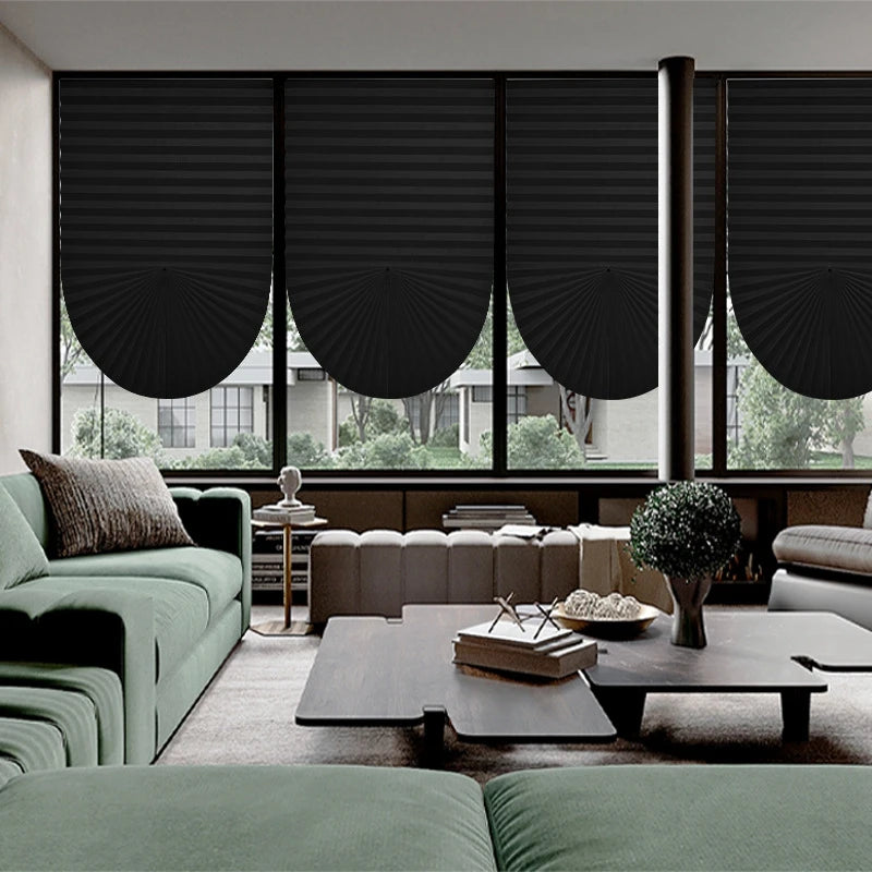 Interior view of a modern living room featuring black pleated blackout curtains and dark furniture.