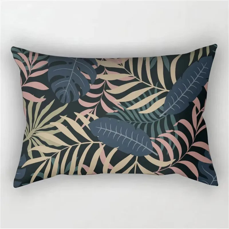 A decorative pillowcase featuring a tropical leaf print design in shades of dark blue, pink, and olive green.