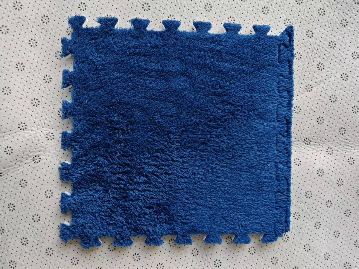 A deep blue plush interlocking puzzle rug mat placed on a light-colored surface.