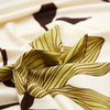 A close-up of stylish printed sofa protector covers featuring olive green stripes and dark brown leaf patterns on a white bac
