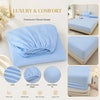 A stack of light blue premium fitted sheets with various texture details and care features shown on a white background.