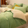 A luxurious flannel duvet cover set in sage green and cream tones with a yellow accent pillow on a bed.