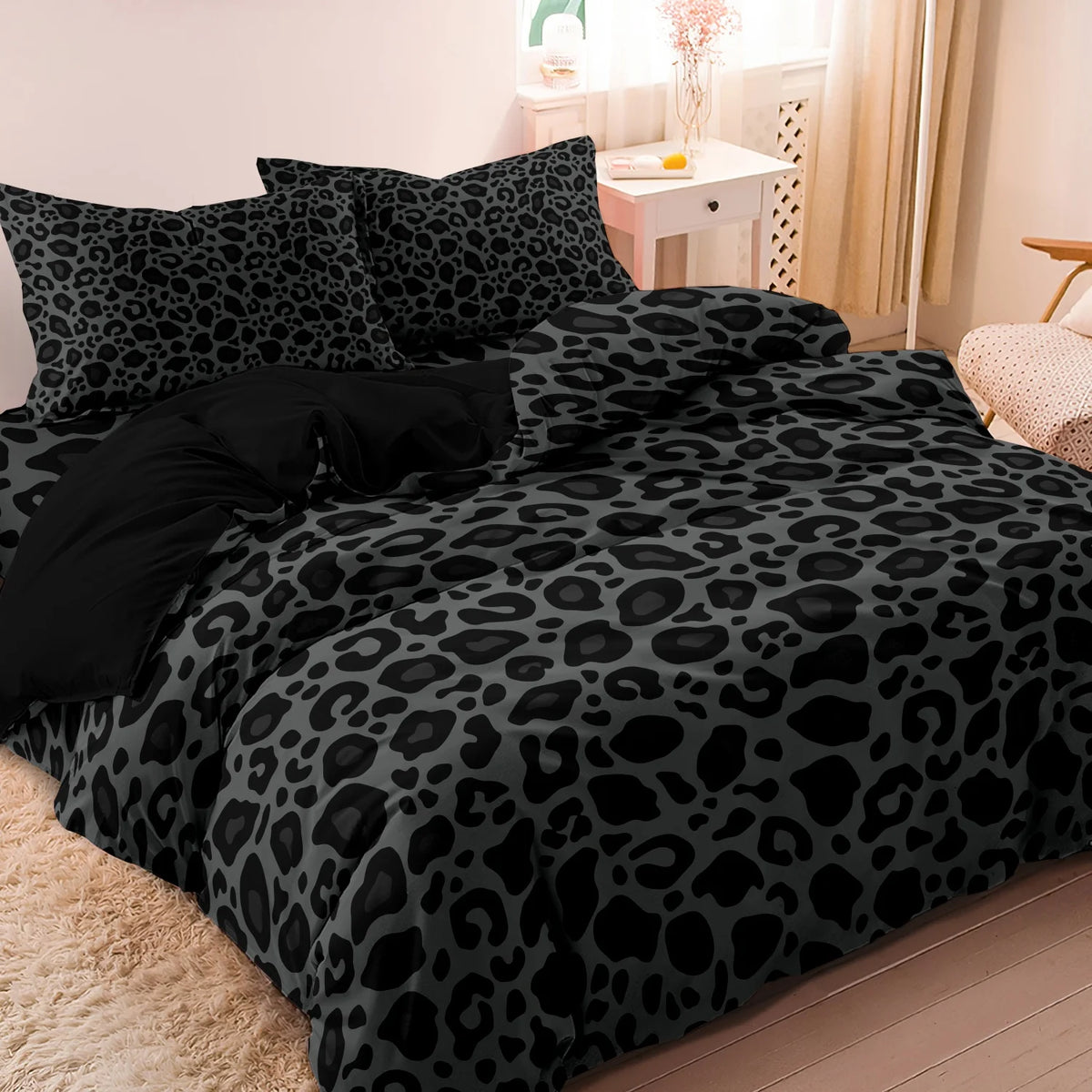 A black and gray leopard print duvet cover set displayed on a bed.