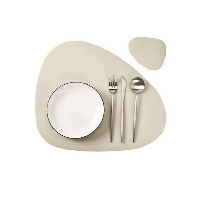 A set of beige reusable vinyl placemats, a white plate, and silverware are displayed on a light background.
