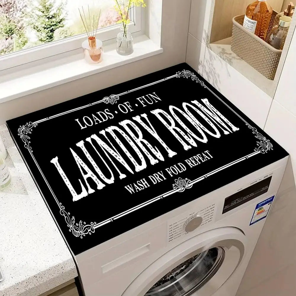 A black sign with white text reads LOADS OF FUN LAUNDRY ROOM WASH DRY FOLD REPEAT placed on a white laundry room appliance.