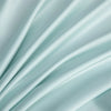 Soft, flowing light blue bamboo flat sheets draped in elegant folds.