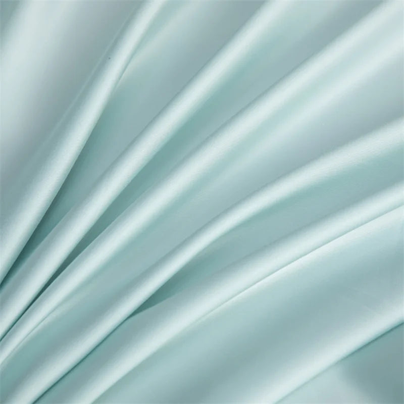 Soft, flowing light blue bamboo flat sheets draped in elegant folds.