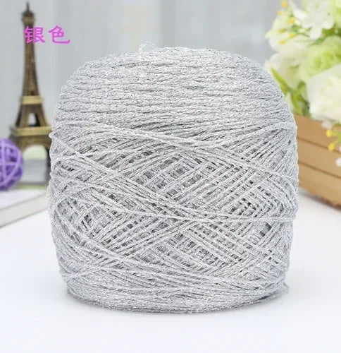 A ball of silver metallic silk yarn used for crocheting and knitting.
