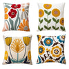 Four throw pillows featuring embroidered floral designs in shades of red, orange, yellow, and green on a white background