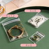 Clear plastic jewelry storage bags with various sizes like 6x8, 8x12, and 4x6 holding gold and silver rings.