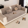 A beige sofa cushion cover with gray fabric and light trim rests on a cream rug.