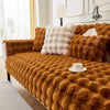 A luxurious, textured, burnt orange plush rabbit fur sofa cushion cover draped over a sofa.