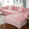 A pink velvet L-shaped sectional sofa with matching throw pillows in a bright room.