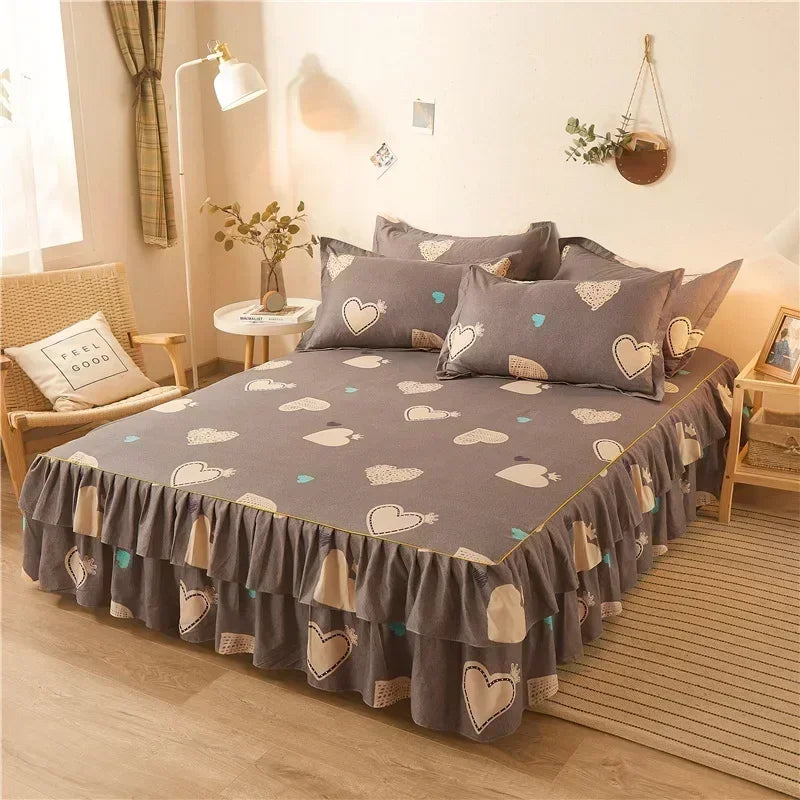 A gray double layer printed bed skirt with white heart and leaf patterns on a bed.