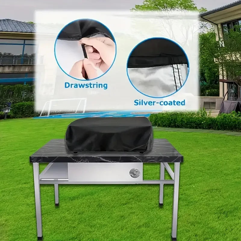 Black heavy-duty BBQ grill cover with drawstring and silver coating displayed on a metal table.