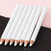 A set of white bamboo chalk pencils with wooden tips arranged diagonally on a black surface.