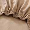 A close-up of a beige stretch pu leather waterproof bench slipcover with gathered fabric detailing.