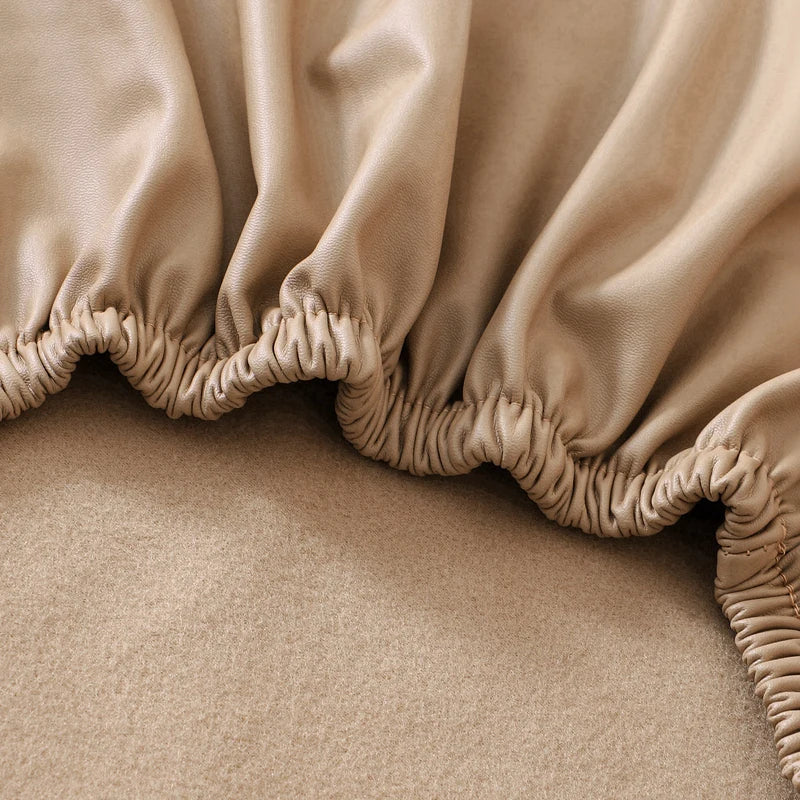A close-up of a beige stretch pu leather waterproof bench slipcover with gathered fabric detailing.