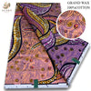 A close-up of a vibrant purple and orange African wax print fabric roll.