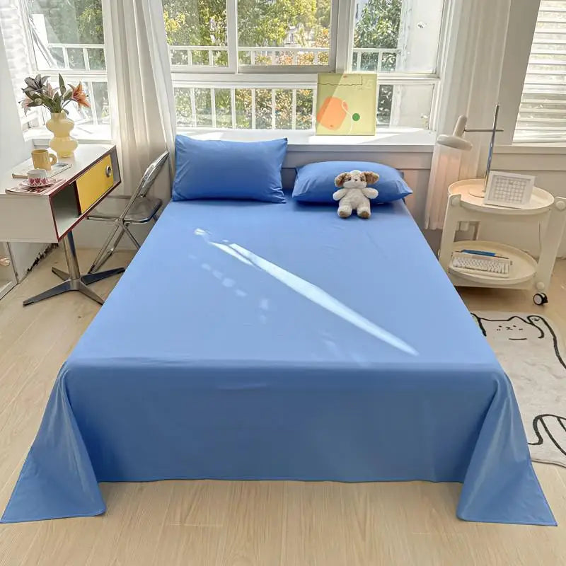 A light blue organic cotton bedding set displayed on a bed with white furniture and natural light.
