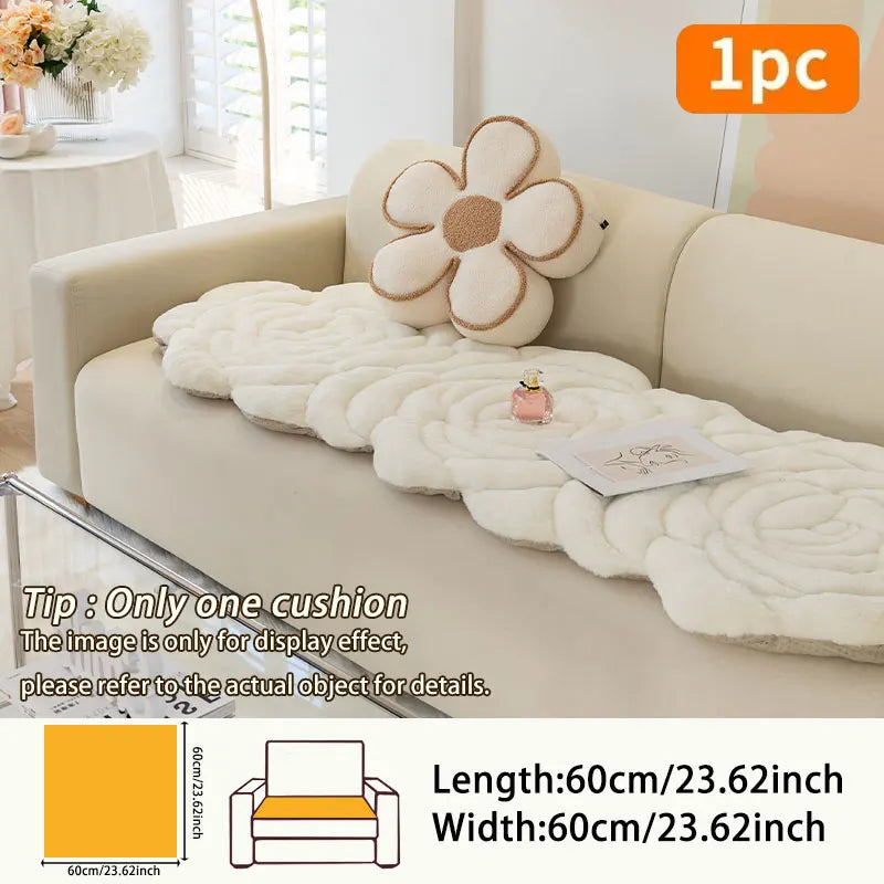 A beige sofa is covered with a fluffy, cream-colored cushion mat featuring a floral design.