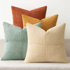 A set of four neutral corduroy throw pillow covers in shades of orange, yellow, and beige with a patchwork design.