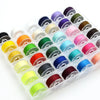 A plastic container filled with an assortment of colored sewing thread bobbins.